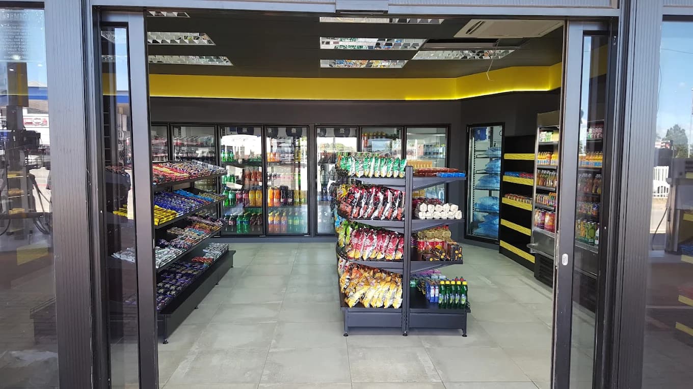 Inside the BUZZ Café convenience store showing snack aisles and drinks fridges
